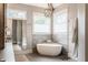 Relaxing bathroom with a soaking tub, modern chandelier, and beautiful tile work at 7602 N Pennsylvania St, Indianapolis, IN 46240