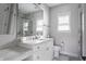 Bright bathroom featuring marble countertop, marble tile shower, and white cabinets at 7602 N Pennsylvania St, Indianapolis, IN 46240