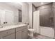 Bathroom featuring modern gray tile, marble floor, and vanity with marble countertop at 7602 N Pennsylvania St, Indianapolis, IN 46240
