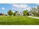 Expansive front lawn showcasing a stunning white modern farmhouse with lush green trees at 7602 N Pennsylvania St, Indianapolis, IN 46240