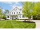 Beautiful white modern farmhouse featuring a lush green lawn and mature trees at 7602 N Pennsylvania St, Indianapolis, IN 46240