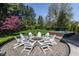 Circular brick patio with Adirondack chairs surrounding a fire pit and swim spa at 7602 N Pennsylvania St, Indianapolis, IN 46240