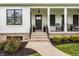 Inviting front porch with classic details, black door, and comfortable seating area at 7602 N Pennsylvania St, Indianapolis, IN 46240