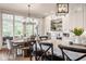 Bright kitchen with island seating, a rustic wooden dining table, and a view of the outdoor patio at 7602 N Pennsylvania St, Indianapolis, IN 46240