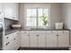 Well-organized laundry room with white cabinets, modern countertops, and a bright window at 7602 N Pennsylvania St, Indianapolis, IN 46240