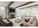 Spacious living room with stone fireplace, wooden beams, and abundant natural light at 7602 N Pennsylvania St, Indianapolis, IN 46240