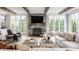 Bright living room featuring a stone fireplace, wooden beams, and large windows at 7602 N Pennsylvania St, Indianapolis, IN 46240