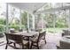 Screened patio with a wooden dining set, comfortable wicker seating, and tranquil backyard views at 7602 N Pennsylvania St, Indianapolis, IN 46240