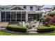 Brick patio with white Adirondack chairs encircling a fire pit, outdoor table, chairs, grill, and landscaping at 7602 N Pennsylvania St, Indianapolis, IN 46240