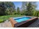 Swim spa surrounded by brick pavers and lush landscaping in a private yard at 7602 N Pennsylvania St, Indianapolis, IN 46240