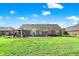 Expansive backyard featuring a brick home, covered patio with a hot tub, and lush lawn at 7618 Ballyshannon St, Indianapolis, IN 46217