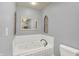 Bathroom featuring white jacuzzi tub with tile surround at 7618 Ballyshannon St, Indianapolis, IN 46217
