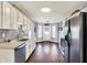 Bright kitchen featuring white cabinets, stainless steel appliances, and an open doorway to the front of the home at 7618 Ballyshannon St, Indianapolis, IN 46217