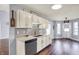 Kitchen showcasing white cabinets, stainless steel dishwasher, sink, and a view to the patio at 7618 Ballyshannon St, Indianapolis, IN 46217
