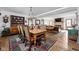 Open-concept dining room leading to the living room, featuring hardwood floors and vintage furnishings at 775 W Hawthorne St, Zionsville, IN 46077