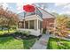 Charming home exterior with a red brick accent, stone pathway, lush lawn, mature landscaping, and a balcony at 775 W Hawthorne St, Zionsville, IN 46077