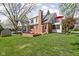 A spacious backyard with lush green grass, mature trees, brick accents, and a charming home exterior at 775 W Hawthorne St, Zionsville, IN 46077