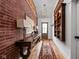Hallway with brick accent wall, wooden floors, decorative shelving and a rustic console table at 775 W Hawthorne St, Zionsville, IN 46077
