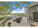 Enjoy this deck overlooking a serene lake with comfortable wicker seating, perfect for relaxing outdoors at 7786 Harbour Isle, Indianapolis, IN 46240