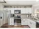 Functional kitchen with white cabinets, granite countertops, and stainless steel appliances, ideal for cooking at 7786 Harbour Isle, Indianapolis, IN 46240