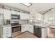 Modern kitchen with granite countertops, white cabinets, and stainless steel appliances, open to the living area at 7786 Harbour Isle, Indianapolis, IN 46240