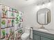 Charming bathroom with unique cactus shower curtain, granite vanity, and stylish mirror at 7829 Hedgehop Dr, Zionsville, IN 46077