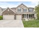 Charming two-story home featuring a three-car garage, brick accents, and a welcoming front porch at 7829 Hedgehop Dr, Zionsville, IN 46077