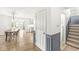 Open-concept hallway featuring gray wainscoting leading to the staircase, kitchen, and dining area at 7829 Hedgehop Dr, Zionsville, IN 46077