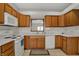Well-lit kitchen with white appliances, and wood cabinets, with a view of the outdoors at 793 Shepherds Way, Greenwood, IN 46143