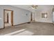 View of the spacious living room with neutral carpet, ceiling fan, and multiple entryways at 793 Shepherds Way, Greenwood, IN 46143