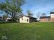 A small outbuilding with chimney sits on a large lot with established trees and plenty of lawn at 798 S 600 W, New Palestine, IN 46163