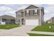 Charming two-story home with gray siding, stone accents, well-manicured lawn, and an attached two-car garage at 813 Sonoma Ln, Greenfield, IN 46140