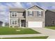 Charming two-story home with gray siding, stone accents, well-manicured lawn, and an attached two-car garage at 813 Sonoma Ln, Greenfield, IN 46140