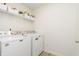 Bright laundry room featuring a washer, dryer, and upper storage shelves at 813 Sonoma Ln, Greenfield, IN 46140