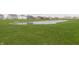 Community pond surrounded by lush green grass and neighborhood homes at 813 Sonoma Ln, Greenfield, IN 46140