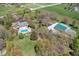 Aerial view of a home, pool, and outbuilding nestled among trees, showcasing a serene and private setting at 8551 E 300 S, Zionsville, IN 46077