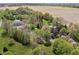 A broad aerial view showcasing a property with a home, pool, outbuilding, and natural surroundings at 8551 E 300 S, Zionsville, IN 46077