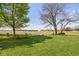 Backyard with a picnic table, fire pit, and mature trees overlooking a peaceful field at 8551 E 300 S, Zionsville, IN 46077