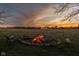 Picturesque outdoor fire pit surrounded by a stone ring, nestled in a vast field with a striking sunset backdrop at 8551 E 300 S, Zionsville, IN 46077