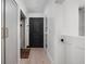 Bright hallway features wood floors, black door, white trim, and closet for functional and stylish transition spaces at 8551 E 300 S, Zionsville, IN 46077