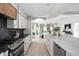 Modern kitchen with sleek white cabinetry, marble countertops, stainless steel appliances, and open to the living area at 8551 E 300 S, Zionsville, IN 46077