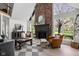 Bright living room features a striking brick fireplace, large windows, and stylish, comfortable seating at 8551 E 300 S, Zionsville, IN 46077