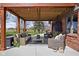 Covered patio featuring comfortable wicker furniture, a TV, and lush greenery, perfect for outdoor living and entertaining at 8551 E 300 S, Zionsville, IN 46077