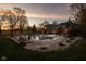 Backyard pool featuring ample seating and relaxing swing against the backdrop of a luxurious brick home at sunset at 8551 E 300 S, Zionsville, IN 46077