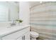 Well-lit bathroom features a shower with striped curtain, toilet, and vanity with bright countertops at 8654 Tripp Rd, Pendleton, IN 46064