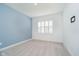 Bright bedroom with light-blue accent wall, plush carpeting, and natural light from shuttered window at 8654 Tripp Rd, Pendleton, IN 46064