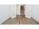 Hallway features wood-look flooring and views to staircase through decorative french doors at 8654 Tripp Rd, Pendleton, IN 46064