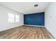 Bright living room boasts wood-look floors, blue accent wall, and ample natural light at 8654 Tripp Rd, Pendleton, IN 46064