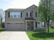 Charming two-story home with a well-manicured lawn, attached garage, and neutral-colored siding at 9045 Stones Bluff Pl, Indianapolis, IN 46113