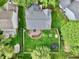 Aerial shot of a home with a backyard, wooden deck, green grass, fire pit and partial fence at 9099 Merrill Ct, Fishers, IN 46038